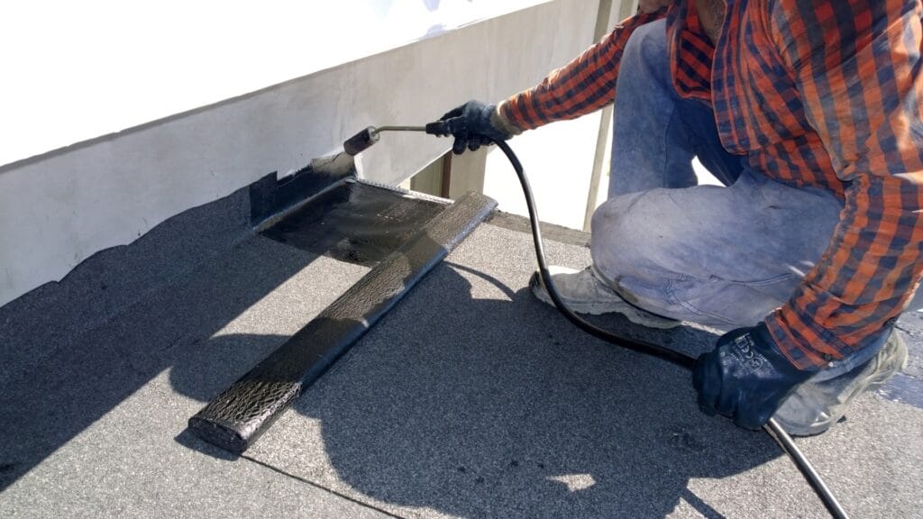 deck-waterproofing-torch-on Professional torch-on waterproofing membrane being applied to deck surface by Auckland waterproofing contractors