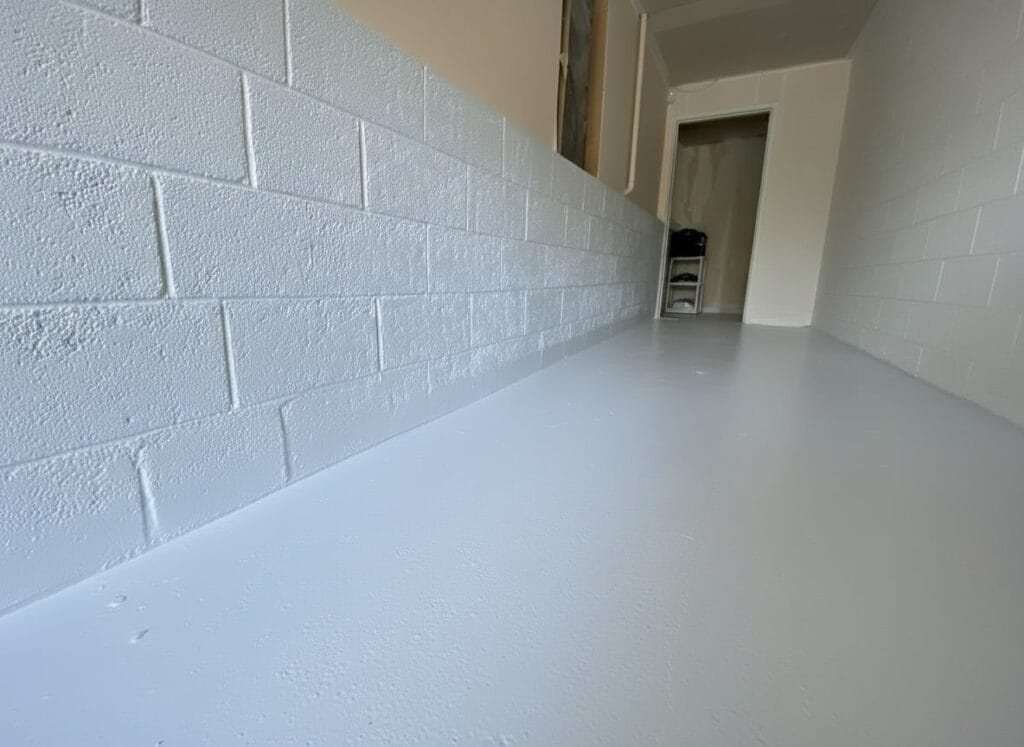 White waterproofed basement floor and concrete block walls with freshly applied membrane coating in Auckland home